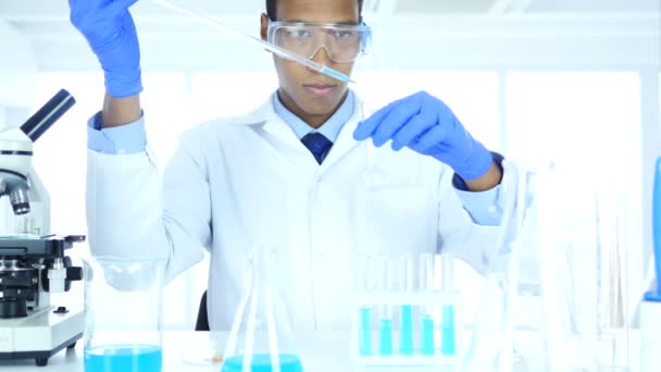 Wetenschapper werken in laboratorium, chemische oplossing in reageerbuis gieten — Stockvideo