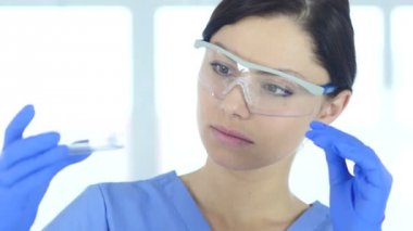 Tüp laboratuvar mavi çözümde bakarak genç bilim adamı