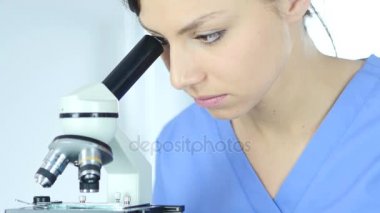 Erkek doktor mikroskop laboratuvarda araştırma için kullanarak.