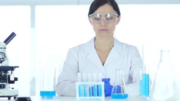 Επιστήμονας Reseach φορώντας προστατευτικά γυαλιά, κάθεται στο εργαστήριο — Αρχείο Βίντεο