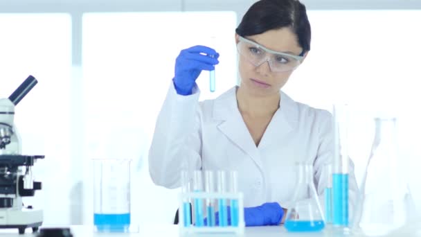 Ricercatore, medico guardando la soluzione blu in provetta in laboratorio — Video Stock