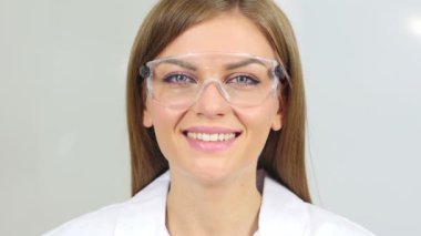 Gülümseyen kadın kimyacı, kameraya bakarak bilimsel