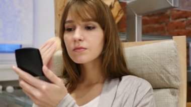 Yüzüne makyaj yapan genç bir kadın.