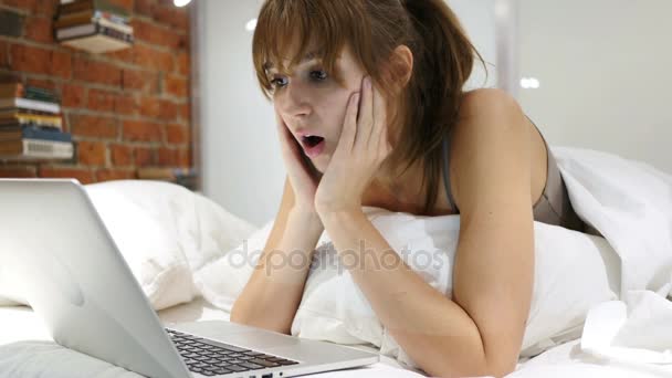Mujer maravilla en la cama en shock por los resultados en el ordenador portátil — Vídeo de stock