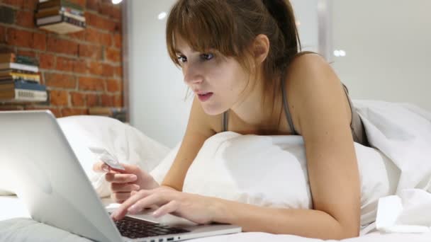 Ошибка в системе онлайн-платежей: расстроенная женщина в постели пытается сделать покупки в Интернете — стоковое видео