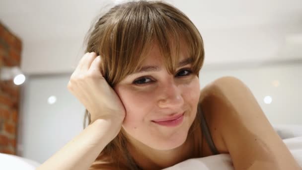 Nahaufnahme des Gesichts einer jungen Frau, die im Bett liegt — Stockvideo
