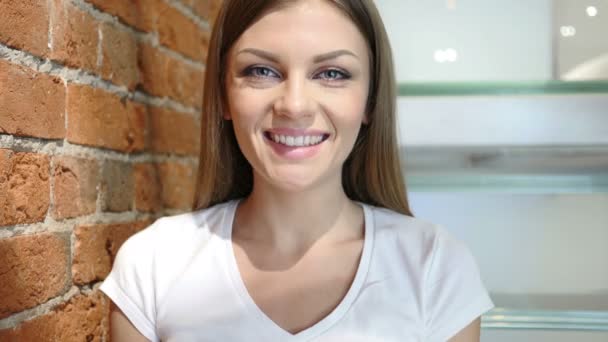 Portret van glimlachen jonge vrouw zit op stoel ontspannen — Stockvideo