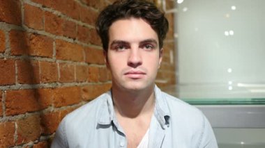 Loft iç oturan ciddi genç adam portresi