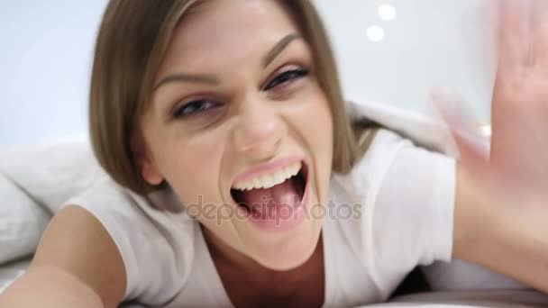 Olá, acolhedora mulher feliz na cama acenando mão — Vídeo de Stock