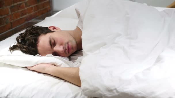 Jovem dormindo de lado na cama à noite — Vídeo de Stock