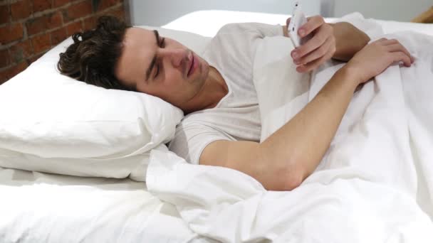 Muž v posteli procházení na Smartphone v noci — Stock video