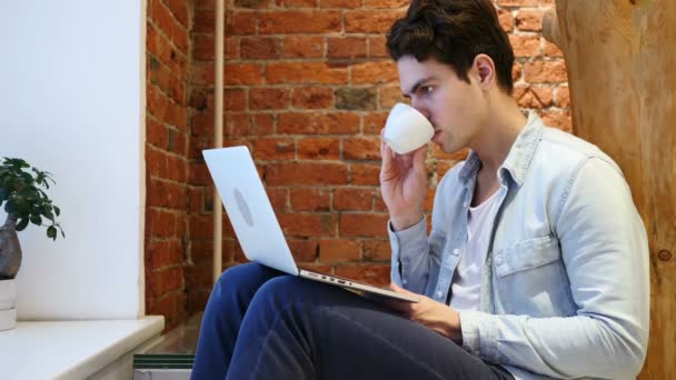 Portrait de jeune homme buvant du café et travaillant sur ordinateur portable — Video