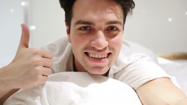 Thumbs Up van gelukkig Man in Bed op buik liggen — Stockvideo