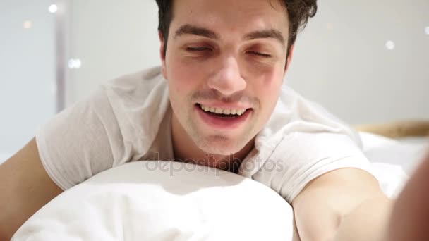 Yatakta yatarken, kabul için başını sallayarak genç adam tarafından Evet — Stok video
