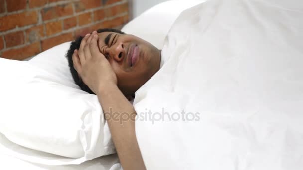 Homem africano tenso perturbado com dor de cabeça na cama à noite — Vídeo de Stock
