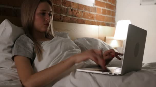 Frau im Bett arbeitet am Laptop und reagiert auf Erfolg — Stockvideo
