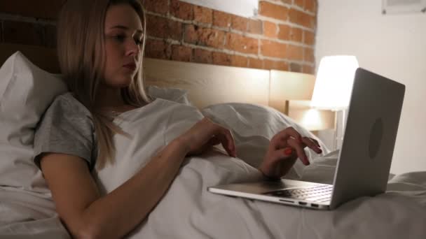 Bolest hlavy, unavená žena pracující na notebook v posteli — Stock video