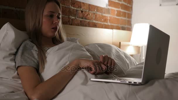 Mujer molesta en la cama trabajando en el ordenador portátil y reaccionando a la pérdida — Vídeo de stock