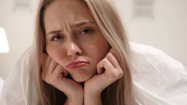Triste jovem mulher cara de perto na cama — Vídeo de Stock