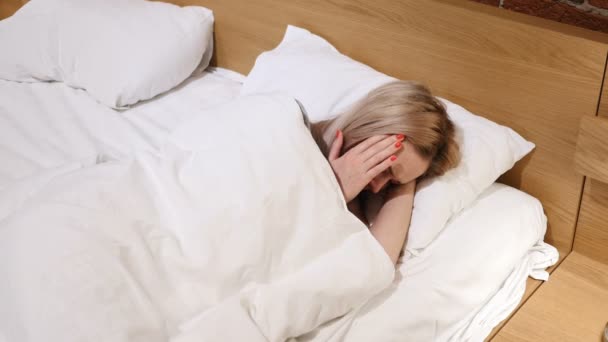 Ból głowy, Kobieta z bólem w łóżku leżąc w łóżku — Wideo stockowe