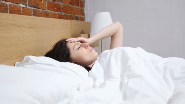 Расстроенная женщина плачет в постели ночью — стоковое видео