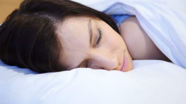 Закрытие юной женщины, спящей в постели ночью — стоковое видео