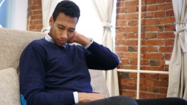 Boyun ağrısı, kanepeye, çatı katında oturan yorgun genç Afrika adam