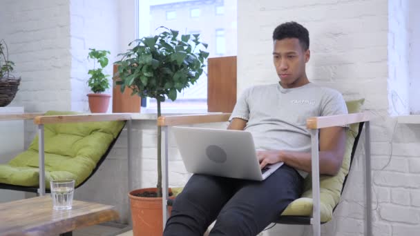 Hombre joven africano escribiendo, trabajando en el ordenador portátil — Vídeo de stock