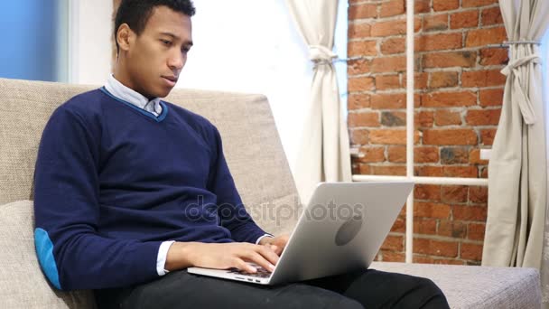 Afryki człowiek w napięcie i ból głowy, działa na laptopie, Strona główna — Wideo stockowe