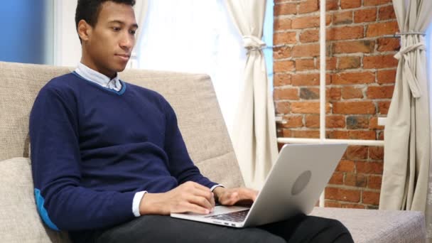 Afrikansk Man göra videochatt på Laptop, sitter på soffan hemma — Stockvideo