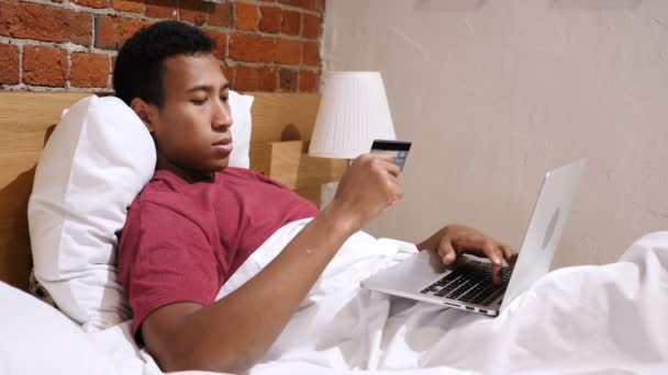 Online betaling mislukking, boos Afrikaanse Man in Bed proberen om Online te winkelen — Stockvideo