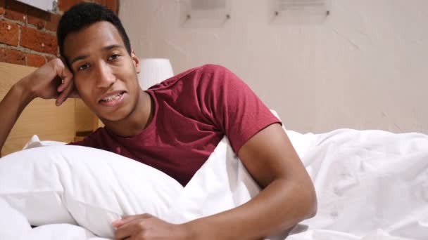 Duimen omhoog door gelukkig Afrikaanse Man liggend in Bed aan kant — Stockvideo