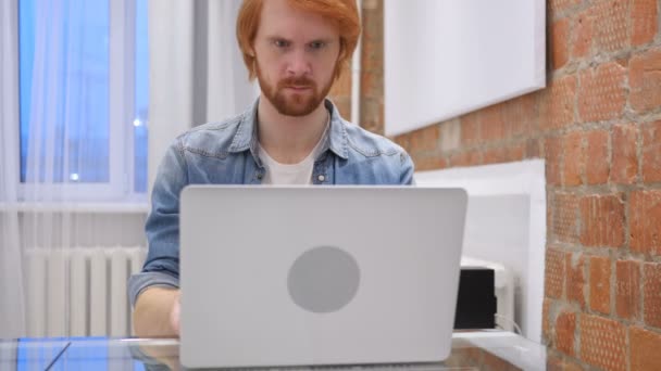 Müder Rotschopf mit Bart arbeitet im Büro — Stockvideo