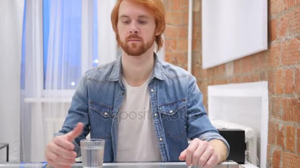 Портрет молодої рудої бороди Людина п'є воду зі скла — стокове відео
