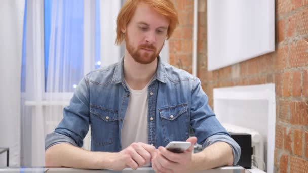 Redhead Beard Man Using Smartphone for Online Browsing — Stock Video