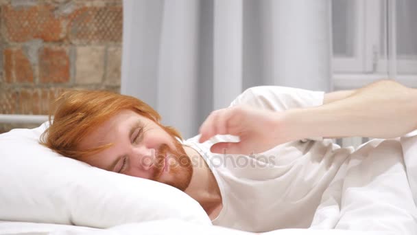 Homem de barba ruiva com dor no pescoço tentando relaxar na cama — Vídeo de Stock