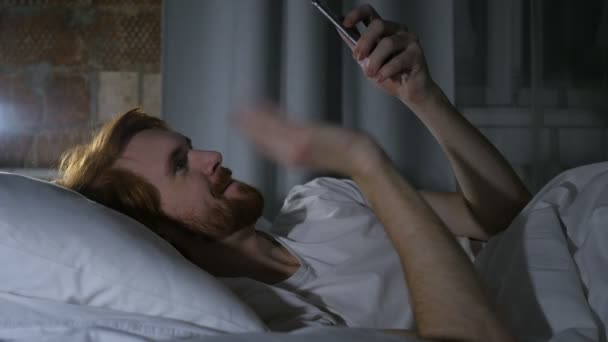Chat de vídeo online por homem de barba ruiva deitado na cama — Vídeo de Stock