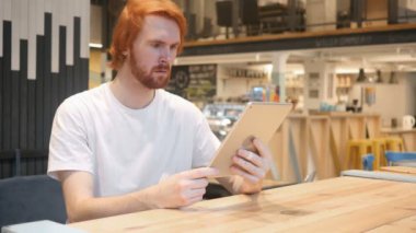 Kızıl saçlı sakallı adam şok, Cafe Tablet PC'de e-posta okuma