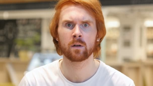 Портрет рыжеволосого бородатого человека в гневе, кричащего в кафе — стоковое видео