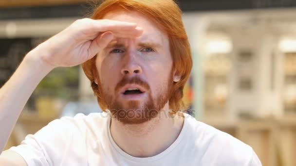 Buscando Gesto por Redhead Barba Hombre Sentado en Café — Vídeos de Stock