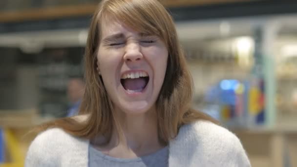 Портрет кричащей молодой женщины, кричащей в кафе — стоковое видео
