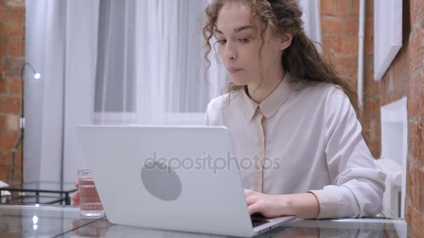 Retrato de una joven bebiendo café y trabajando en un ordenador portátil — Vídeo de stock