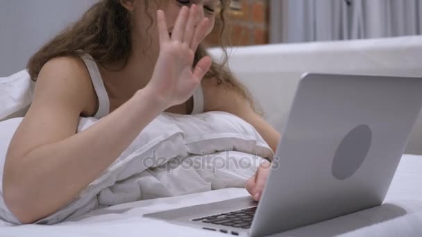침대에서 노트북에 온라인 비디오 채팅을 하 고 흥분된 여성 — 비디오
