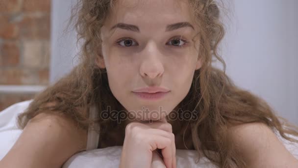 Młoda kobieta twarzy leżącego w łóżku z bliska — Wideo stockowe