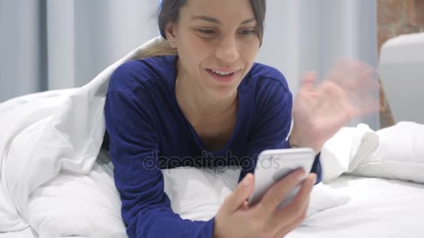Chat vidéo en ligne sur Smartphone par femme hispanique au lit — Video