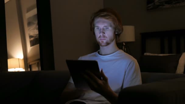 Pelirroja hombre usando tableta computadora en la noche — Vídeos de Stock