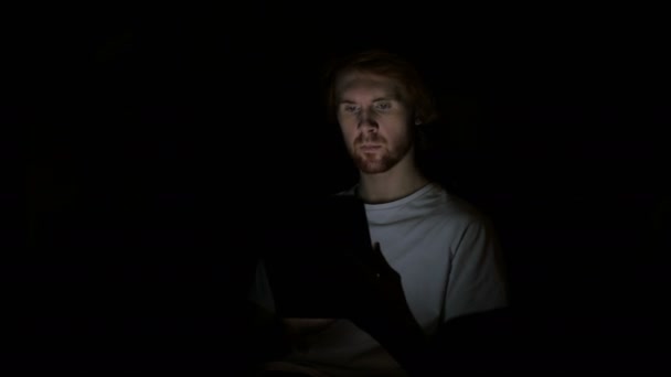 Рыжий человек реагирует на успех при использовании планшета ночью — стоковое видео