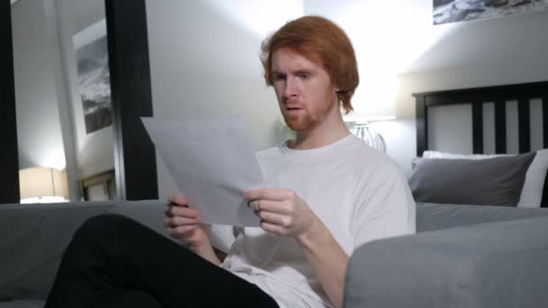 Rudowłosy mężczyzna podekscytowany po czytanie dokumentów — Wideo stockowe