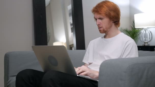 Chockad, förvånad rödhårig Man som arbetar på Laptop — Stockvideo