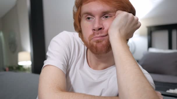 悲しい何気なく座っている赤毛の男のクローズ アップ — ストック動画